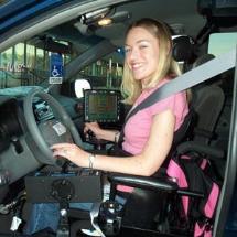 Young woman in a wheelchair at the wheel of her accessible automobile.