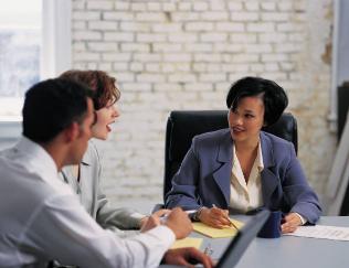 three people talking at a table and smiling